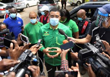 Jamaica’s Prime Minister Andrew Holness talks to the media before casting his vote in the general elections, in Kingston