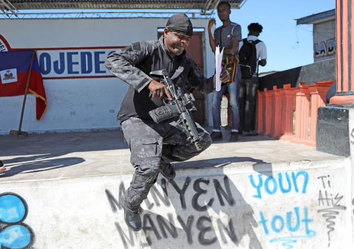 Former police officer Jimmy "Barbecue" Cherizier, leader of the 'G9' coalition, jumps off a terrace after announcing that the blockade of fuel terminals will be temporarily lifted to allow for gasoline distribution after weeks of crippling shortages, in Port-au-Prince, Haiti, Nov. 12, 2021.