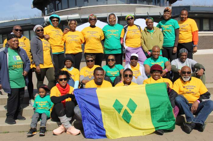 Participants display the Vincentian flag before walking.