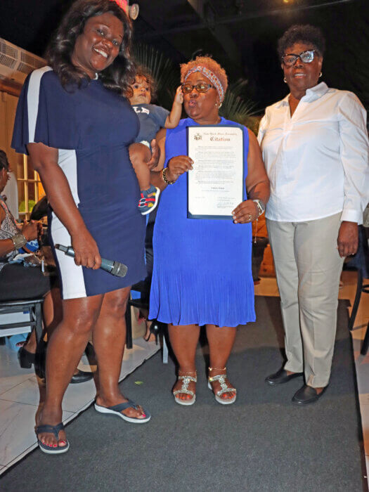 Assemblywoman Rodneyse Bichotte Hermelyn, left, presents citation to Valerie Grant, flanked by Jean Joseph.