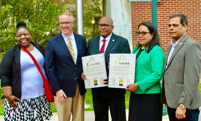 Jamaican-born Trudy King, organizer, left, is photographed with Don Clavin, after Ambassadors, Michael E. Brotherson, and Carolyn Rodrigues Birkett were presented with Citations from the Town of Hempstead, during a Flag Raising ceremony on the Dorothy L. Goosby Plaza. Zayid Syed, Executive Director, Community Affairs is at right.