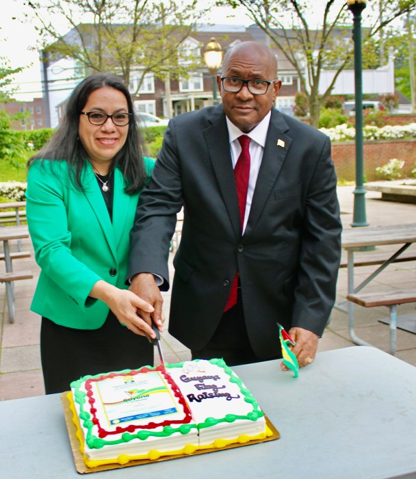 Ambassadors Michael E. Brotherson, and Carolyn Rodrigues Birkett, cut an Independence cake, after raising the Golden Arrowhead flag over the Dorothy L. Goosby Plaza, in Hempstead Township, Long Island on May 17.