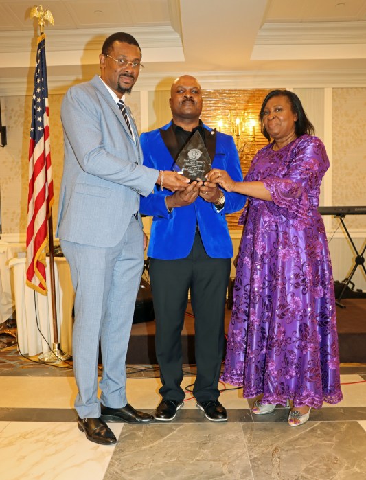 Lesley Richards, center, receives award by UVCGB member Beverly-Ann Wilson, flanked by Consul General Rondy "Luta" McIntosh.