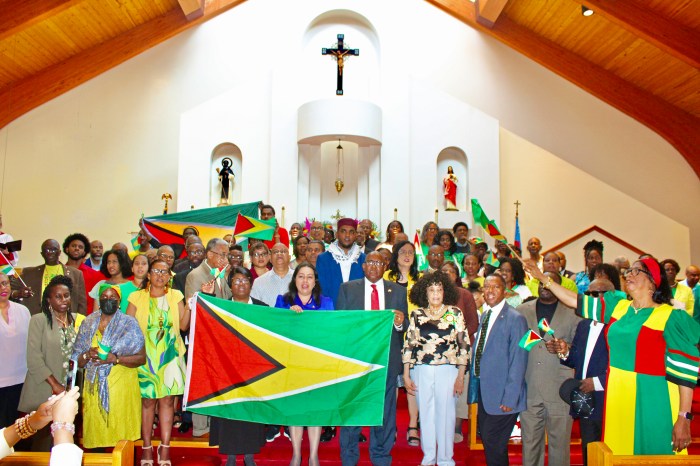 Compatriots join Ambassadors Carolyn Rodrigues Burkett and Michael E. Brotherson, Patricia Jordan-Langford, and spiritual leaders to showcase Guyana's Golden Arrowhead flag, as they all sang the National Anthem at a 58th Independence Anniversary service at St. Gabriel's Episcopal Church in Brooklyn, on May 26, Independence Day.