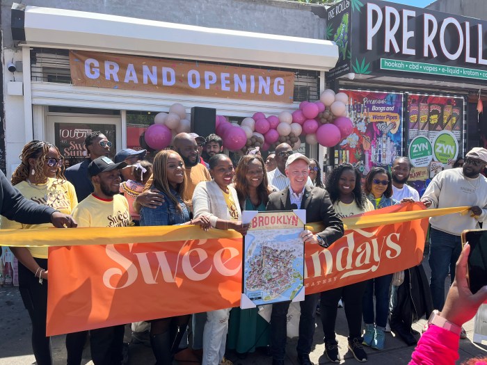 Members of the community and supporters came out to support the opening of this Haitian Black owned cafe. Debbie Esther Louis and Randy Peer hold the Brooklyn sign.