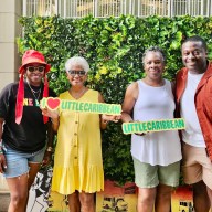 Founder and CEO of I Am Caribbeing, Shelley Worrell, mother, Marva Samaroo, with Charmaine and Jelanie Deshong holding the logo sign at the first One Love Little Caribbean Festival, at Prospect Park Boathouse, on June 23, 2024.