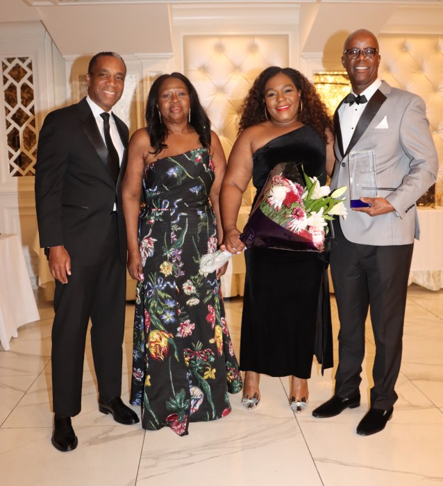 Charles Small, Esq., right, holds award, flanked by Jovia Radix-Seaborough, Esq., Justice Hinds-Radix's eldest daughter, holding bouquet of flowers; Justice Sylvia Hinds-Radix, next to her daughter; and Rudyard Whyte, Esq.