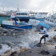 Fishermen pull a boat damaged by Hurricane Beryl back to the dock at the Bridgetown Fisheries in Barbados, Monday, July 1, 2024.