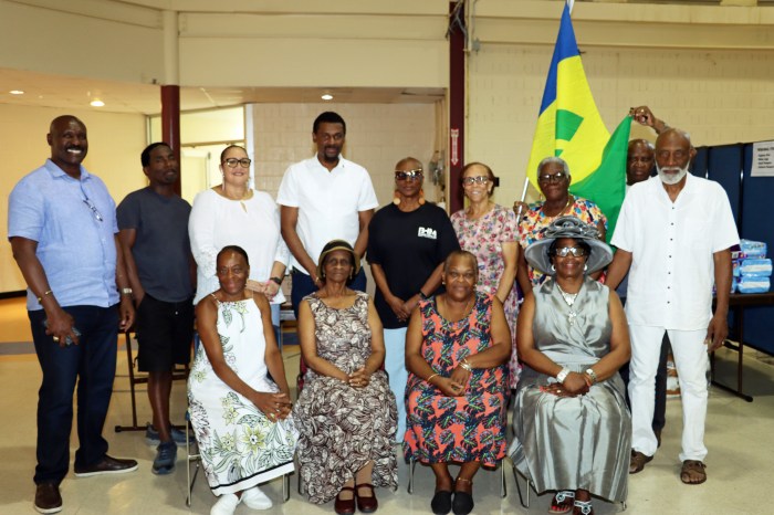 Vincentians pose with national flag, with Consul General Rondy McIntosh, fourth from left, in back row.