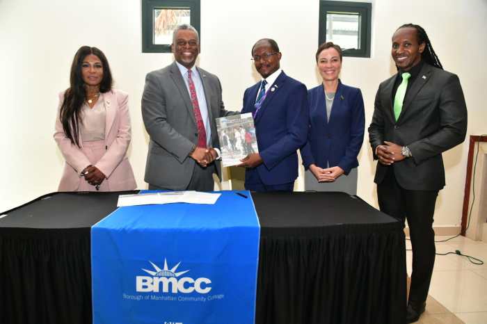 BMCC President Dr. Anthony E. Munroe, left, signs agreement with Prof. Colin Gyles, CD, UCC president, flanked by officials