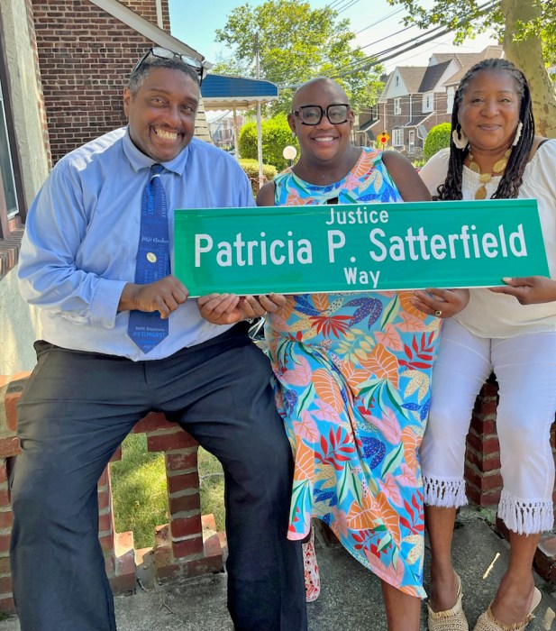 Dr. Danielle N. Williams and her husband, Allen David Williams, Sr., and Daphne Kelly display 'Justice Patricia P. Satterfield Way' sign.