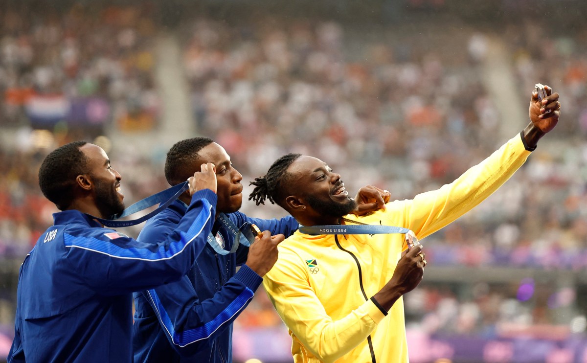 Gold medallist Grant Holloway of United States celebrates on the podium with silver medallist Daniel Roberts of United States and bronze medallist Rasheed Broadbell of Jamaica REUTERS/Alina Smutko