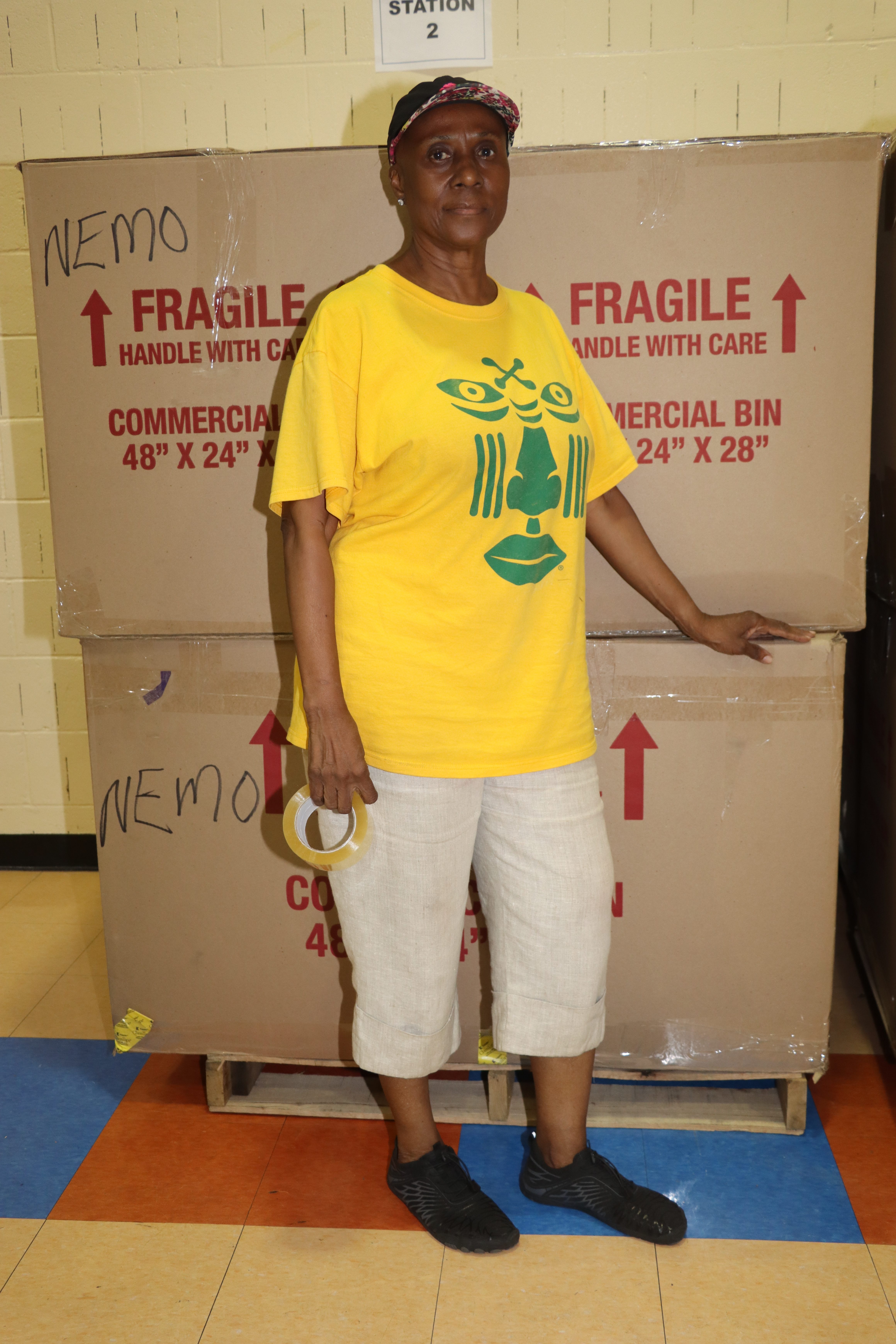 Verna Arthur, president of SVG Relief Committee USA, Inc. stands before boxes to be shipped to St. Vincent and the Grenadines