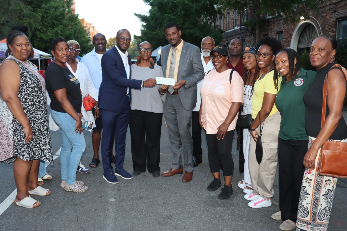 Pastor Louis H. Straker, Jr., in blue suit, fourth from left, presents check to Verna Arthur, to his immediate left, and Consul General Rondy "Luta" McIntosh, flanked by parishioners and members of the SVG Relief Committee USA, Inc.