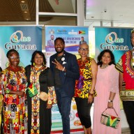 A colorfully dressed group of Guyanese from left Sherry Williams, Claire Patterson Monah, Jenny Persaud, Public Advocate Jumaane Williams, Lourdeth Ferguson, Ramola Persaud, and Leon Jameson Suseran, in the foyer of Medgar Evers College, at an Emancipation Observance hosted by the diplomat office on July 31, at Medgar Evers College.