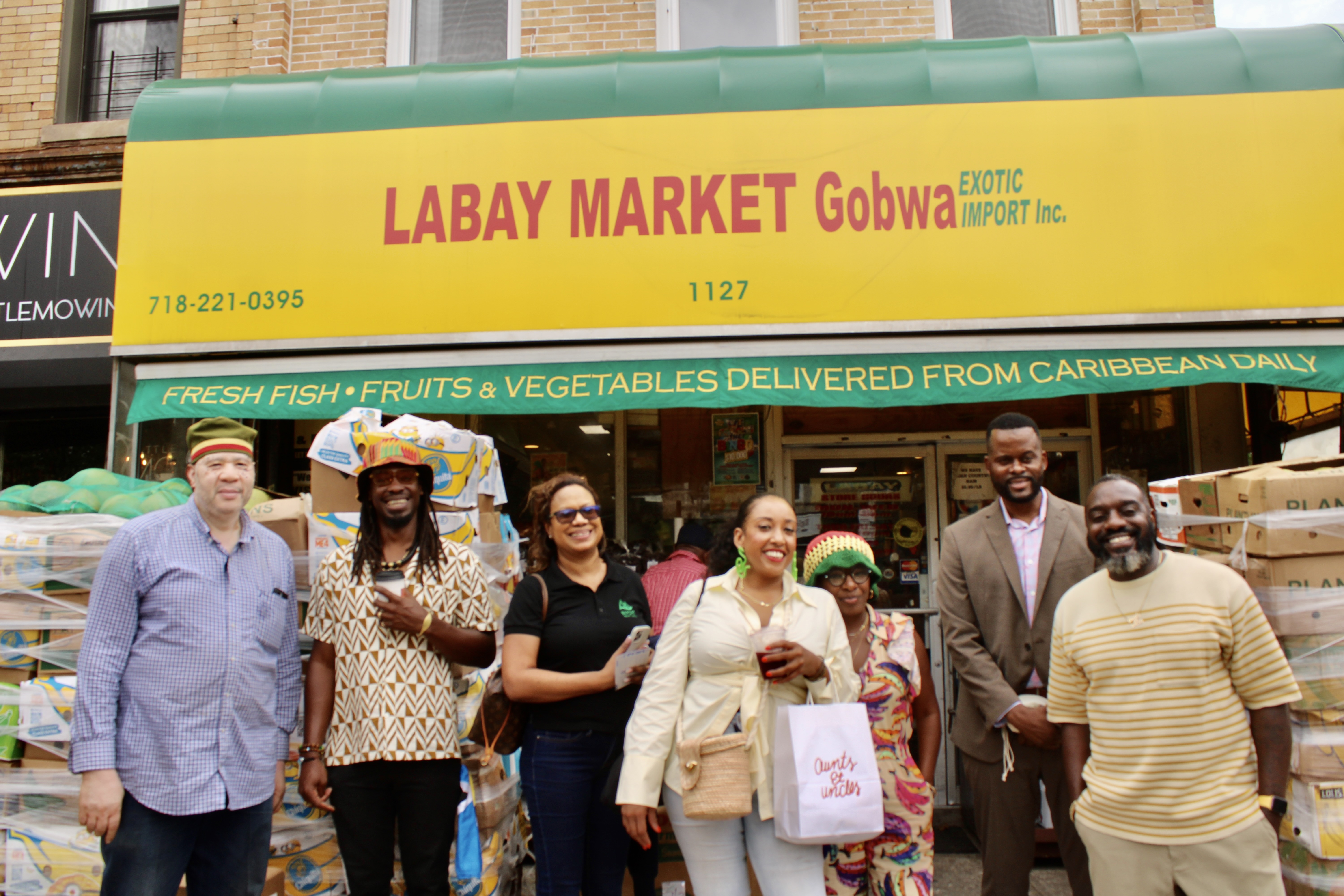 The group gathered outside of Labay Market Exotic Imports, Inc owned by Grenadian-born MacDonald Romain extreme left.