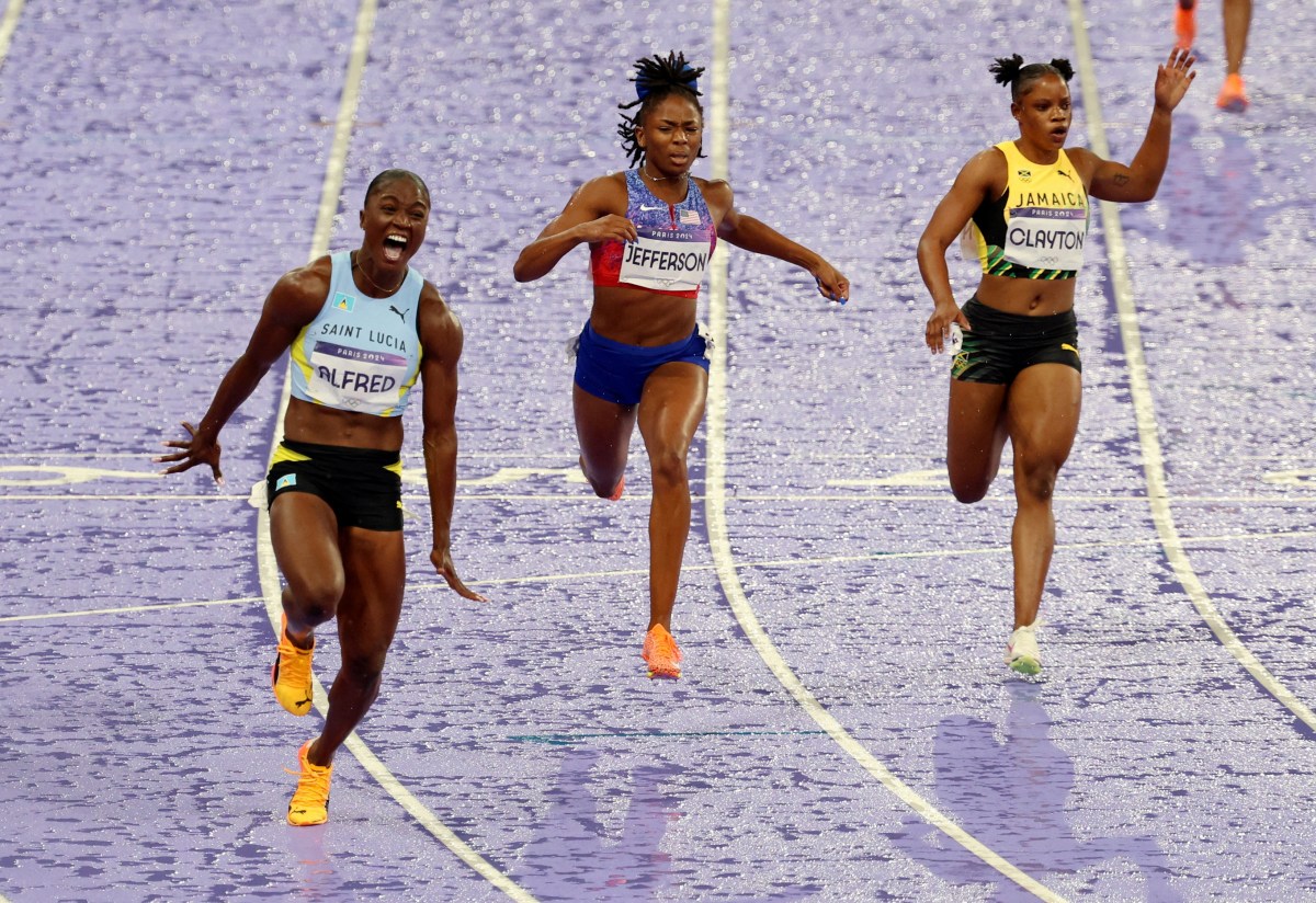 Paris 2024 Olympics - Athletics - Women's 100m Final - Stade de France, Saint-Denis, France - August 03, 2024. Julien Alfred of Saint Lucia crosses the finish line to win the final.