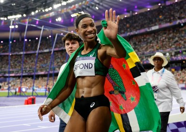 Thea LaFond of Dominica celebrates with her national flag after winning gold.