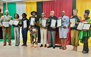 GCA Award recipients holding Stick Figure statues, Proclamations from Congresswoman Yvette D. Clarke, and Citations from Senator Roxanne J. Persaud. From left: Errol Hazelwood, Johanna Rae George, Calvin Booker, Andy Ninvalle, Roxanne Lashley, Dr. Vibert Cambridge, Anthony Alleyne, Lorraine Croft-Farnell, and Latoya Asim.