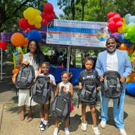 Senator Kevin Parker with a family showcasing backpacks donated by Spectrum at his 17th Annual Back-to-school festival in Paerdegat Park, on Aug. 24.