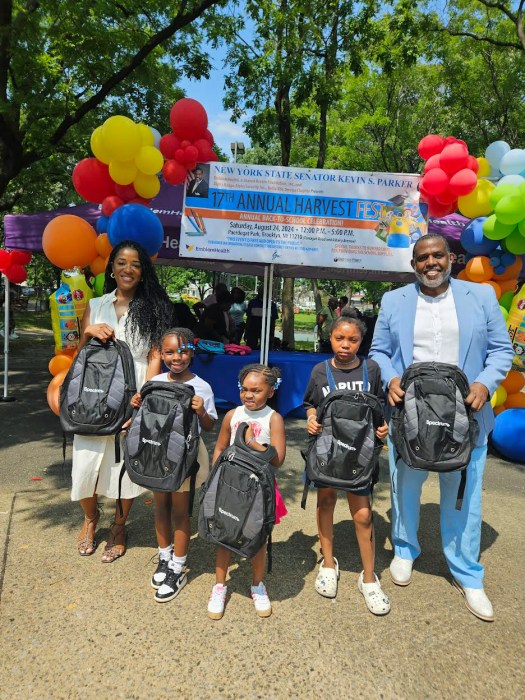 Senator Kevin Parker with a family showcasing backpacks donated by Spectrum at his 17th Annual Back-to-school festival in Paerdegat Park, on Aug. 24.