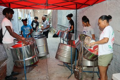 Brian Nicholas, at back, provides advice to Blacklove Steel Orchestra pannists, while members practice at the Pan Yard on East 34th Street in Brooklyn.