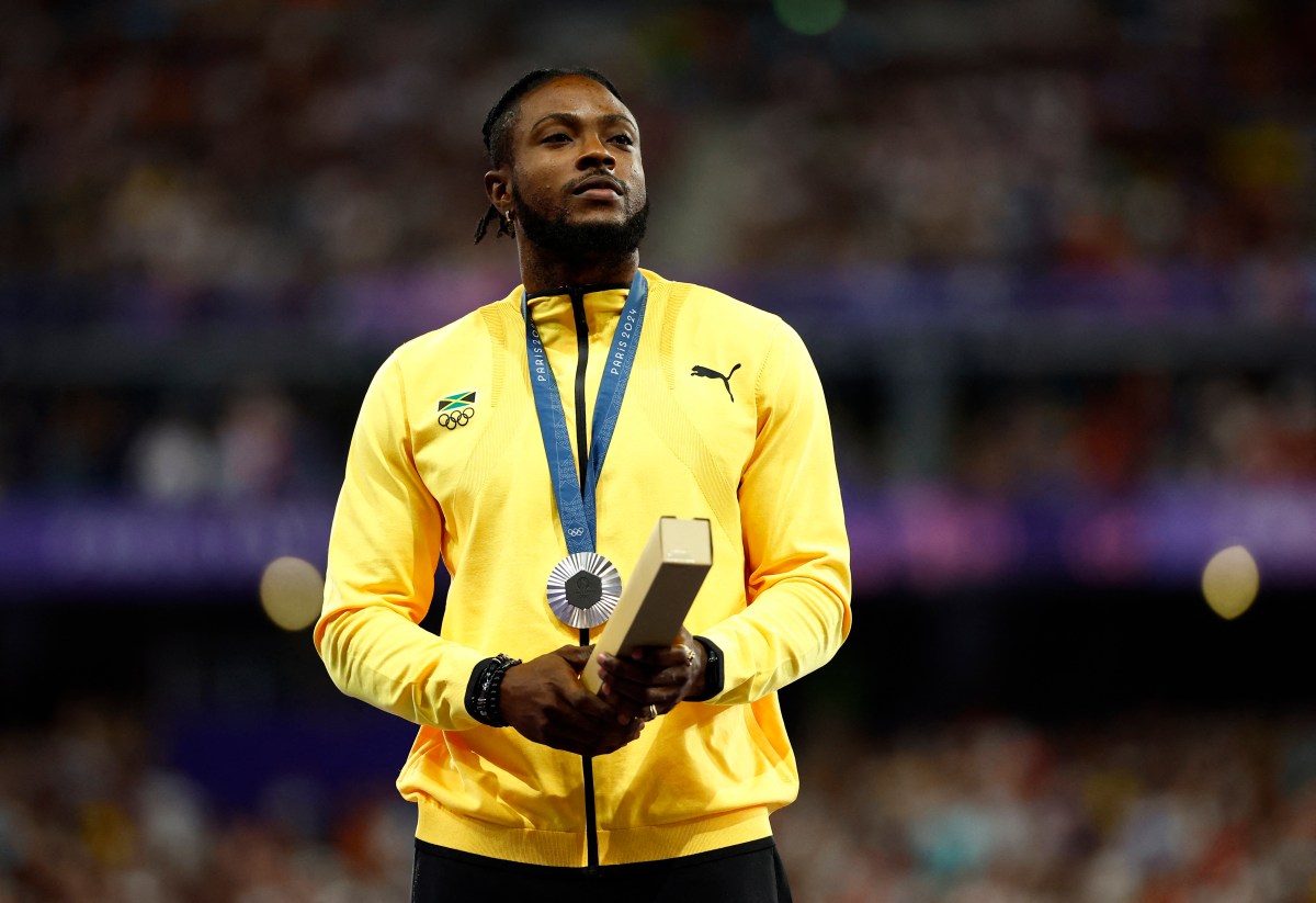 Silver medallist Kishane Thompson of Jamaica stands on the podium.