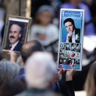 A woman holding a sign attends a ceremony marking the 23rd anniversary of the September 11, 2001 attacks on the World Trade Center at the 9/11 Memorial and Museum in the Manhattan borough of New York City, U.S., Sept. 11, 2024.