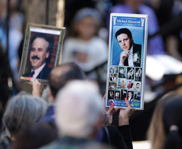 A woman holding a sign attends a ceremony marking the 23rd anniversary of the September 11, 2001 attacks on the World Trade Center at the 9/11 Memorial and Museum in the Manhattan borough of New York City, U.S., Sept. 11, 2024.