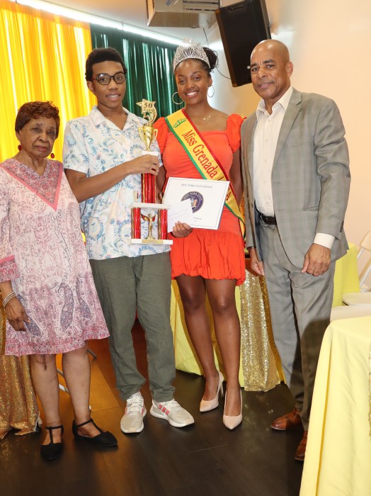 Justin McIntosh received the award, flanked by Cecily Mason, left; Mickalia Forrester-Ewen, Miss Grenada USA; and Consul General Raphael M. Brizan.