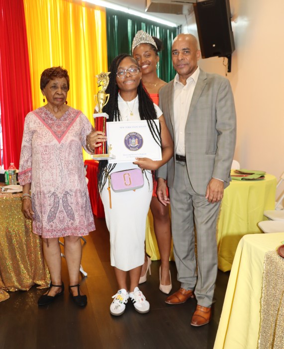 Chyenne Forrester displays award, flanked Cecily Mason, left, president of the Grenadian-American Ex-Teachers' Association; Mickalia Forrester-Ewen, Miss Grenada USA, back; and Consul General Raphael M. Brizan.