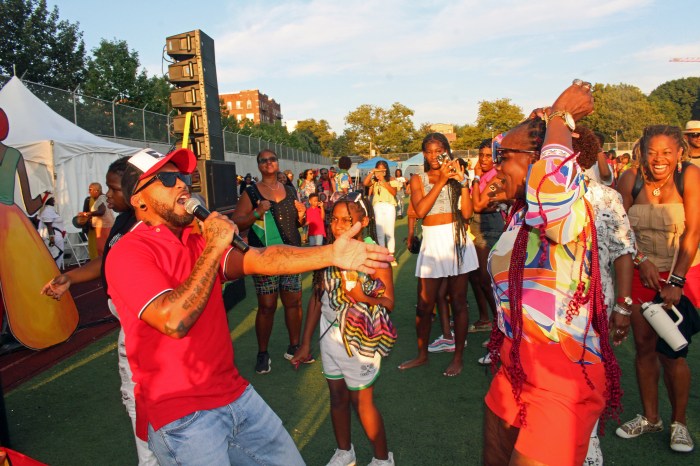 A spirited crowd danced and wave flags at the thrilling performance by Soca Monarch 2023 Adrian Dutchin to end the Folk Festival season at Old Boys and Girls High School in Crown Heights, Brooklyn.