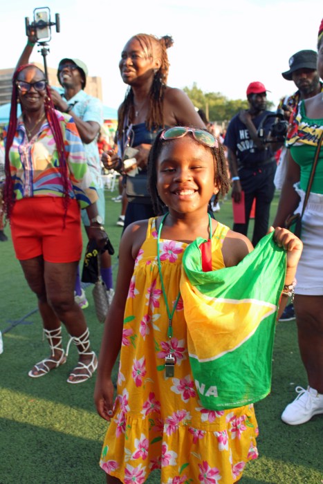 A little Guyanese girl proudly shows off a Golden Arrowhead flag during a riveting cultural presentation to end Folk Festival season at Old Boys and Girls High School in Crown Heights, Brooklyn.