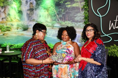 Chioma Iwuagu Udegbunam Phd., and Dr. Ezinne Kalu, Nigerian-born delegates to the 79th Session of the United Nations General Assembly, presented Doris Rodney, owner of Water Fall Lounge, 4703 Church Ave., with an African attire, after an afternoon of conversations on STEM.