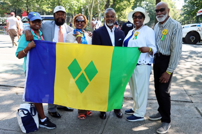 Displaying the Vincy flag at the beginning of the parade route on Buffalo Avenue: Andrew Maloney, Esq., WIADCA chairman, fourth from left, with, left to right: Desma King, Roy Antoine, Ursela Edward (with miniature St. Lucian flag), Ancilla Friday and Crispin Friday.