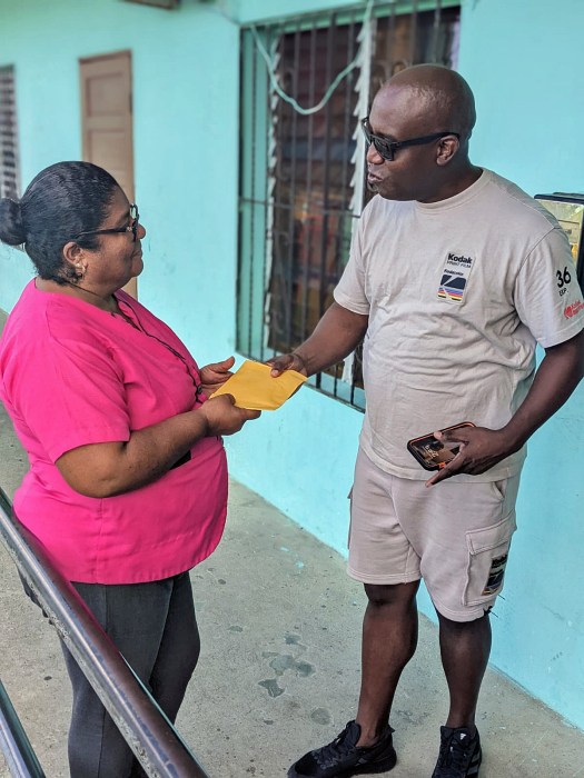 Stella Maris principal Francella Cantun accepts a monetary donation for the school from Nigy Boy, delivered by Soca & Culture Festival co-founder Omar Arzu for the institution.