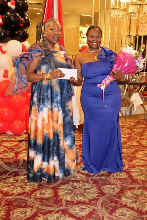 Jocelyn Alleyne presents the scholarship award to Dana John, right.