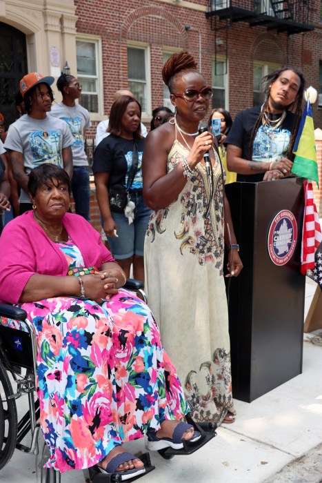 Sherma Chambers addresses ceremony, with her mother Elizabeth "Betty" Nichols seated in wheelchair.