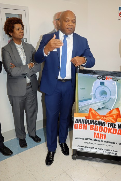 Trinidadian-born Wayne Jordan, director of radiology, addresses the ceremony, with Dr. Sandra Scott, interim CEO, OBH, in the background.