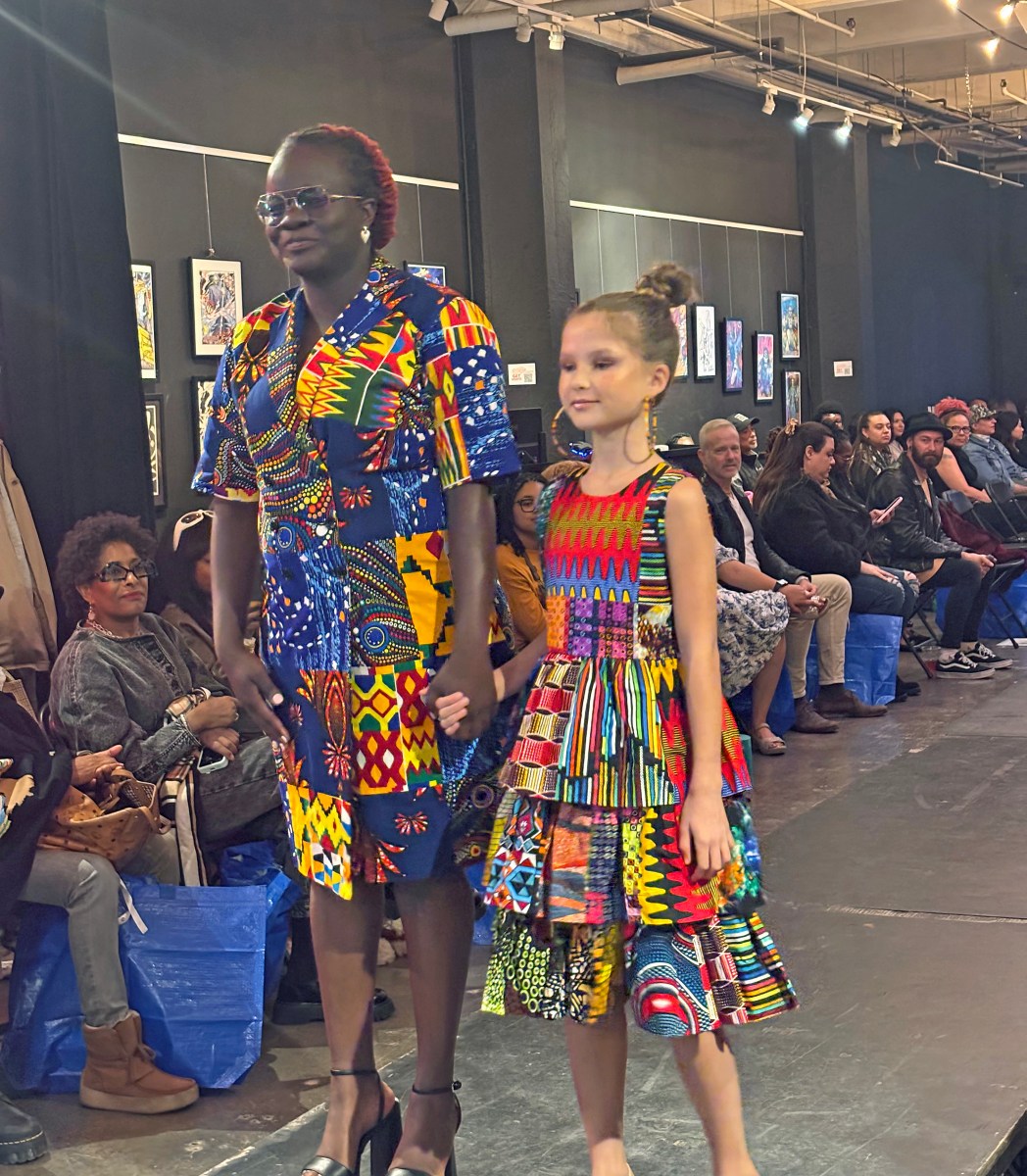 Designer Constance Bernard and a young model showcase a standout piece on the runway.