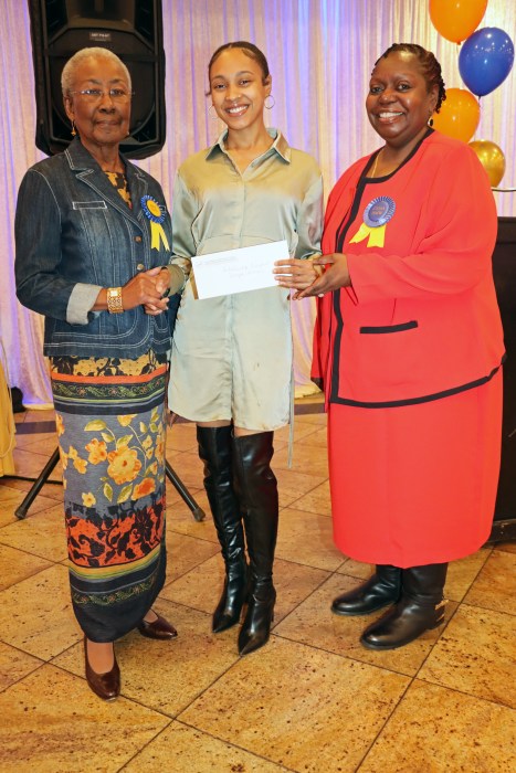 Jamaican-born nursing student Kenya Simms receives a scholarship award from RN Malvin Groce, left, and RN Wendy Lake-Ricke.