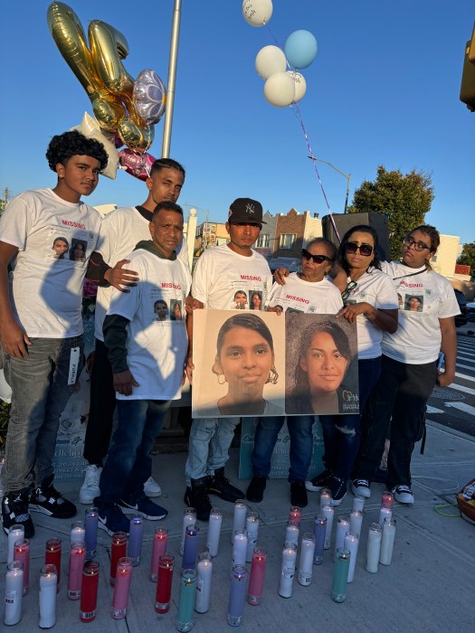 Deniese Hariman’s mother, older sister, brother, and nephews stand together in front of her photos during a candlelight vigil in Queens.