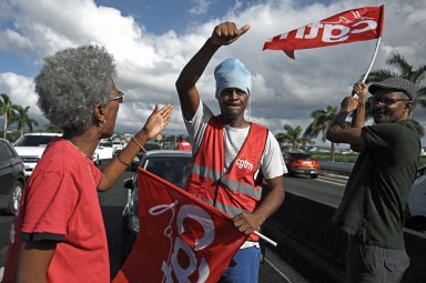 Members of the French union CGT Martinique perform a go slow operation in Fort-de-France, in the French Caribbean island of Martinique, on October 15, 2024, amid riots over rising prices. Authorities in the French Caribbean island of Martinique have extended a night-time curfew following a new wave of riots over spiralling food prices, while talks between authorities and protesters have stalled. In recent weeks the island of 350,000 people has been shaken by violent protests over high food prices.