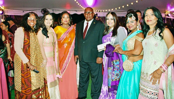 Consul General of Guyana to New York, Michael E. Brotherson, fourth from left, surrounded by a bevy of beautifully dressed Guyanese women under a white tent of Gracie Mansion in Manhattan, on Oct. 24.