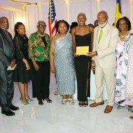 Shafiqua Maloney, fourth from right, receives a gift from Crispin Friday, president of the St. Vincent and the Grenadines Organizations, USA, Inc. (COSAGO), flanked by members of the St. Vincent and the Grenadines Nurses Association, Mas Productions Unlimited, and Vincy Day USA Committee.