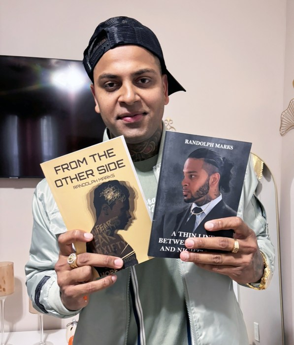 Randolph Marks proudly displays his books as he prepares to write his third one.