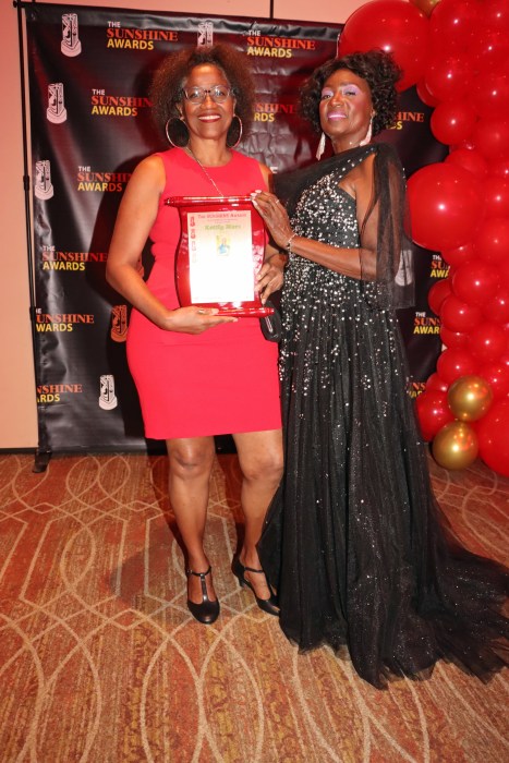 Kettly Mars, left, receives award from Dr. Cynthia Sterling-Fox, marketing and promotions for the SUNSHINE AWARDS.