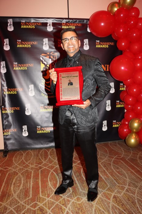 Trinidadian artist Rikki Jai displays his award.