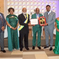 Wesley Millington, fourth from left, receives an award, flanked by COSAGO President Crispin Friday and his wife, Ancilla, to Millington's right; SVG Consul General to the United States Rondy McIntosh and his wife, Semone, to Millington's left; and O'Brien Simmons, left.