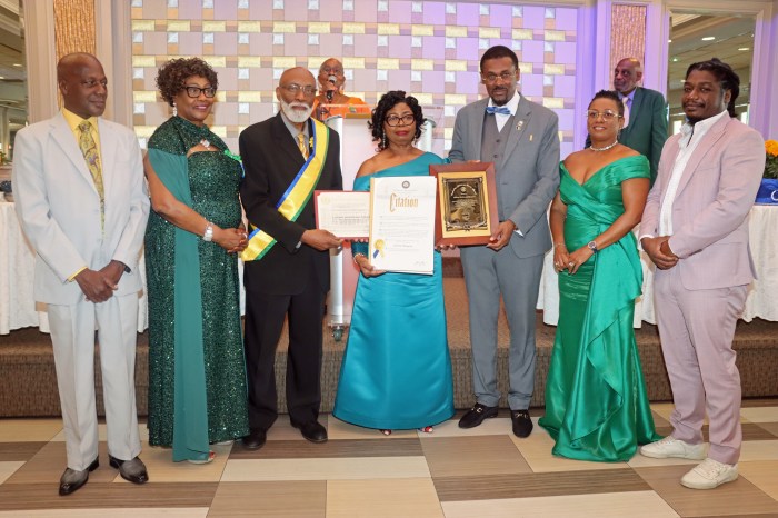 Laverne McDowald-Thompson, center, being assisted with plague, proclamation, and citation by COSAGO President Crispin Friday, to her right; SVG Consul General to the United States Rondy McIntosh, to her left; the wives of Friday and McIntosh; McDowald-Thompson's husband, Almond, left, and their son, Ramon.